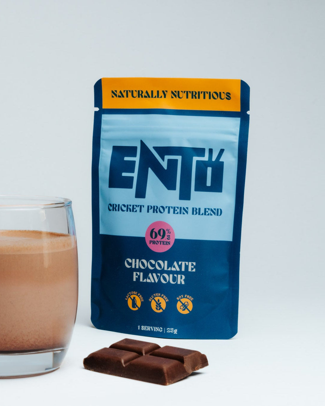 ENTO cricket protein blend package with a glass of chocolate-flavored drink and chocolate bars on a white background